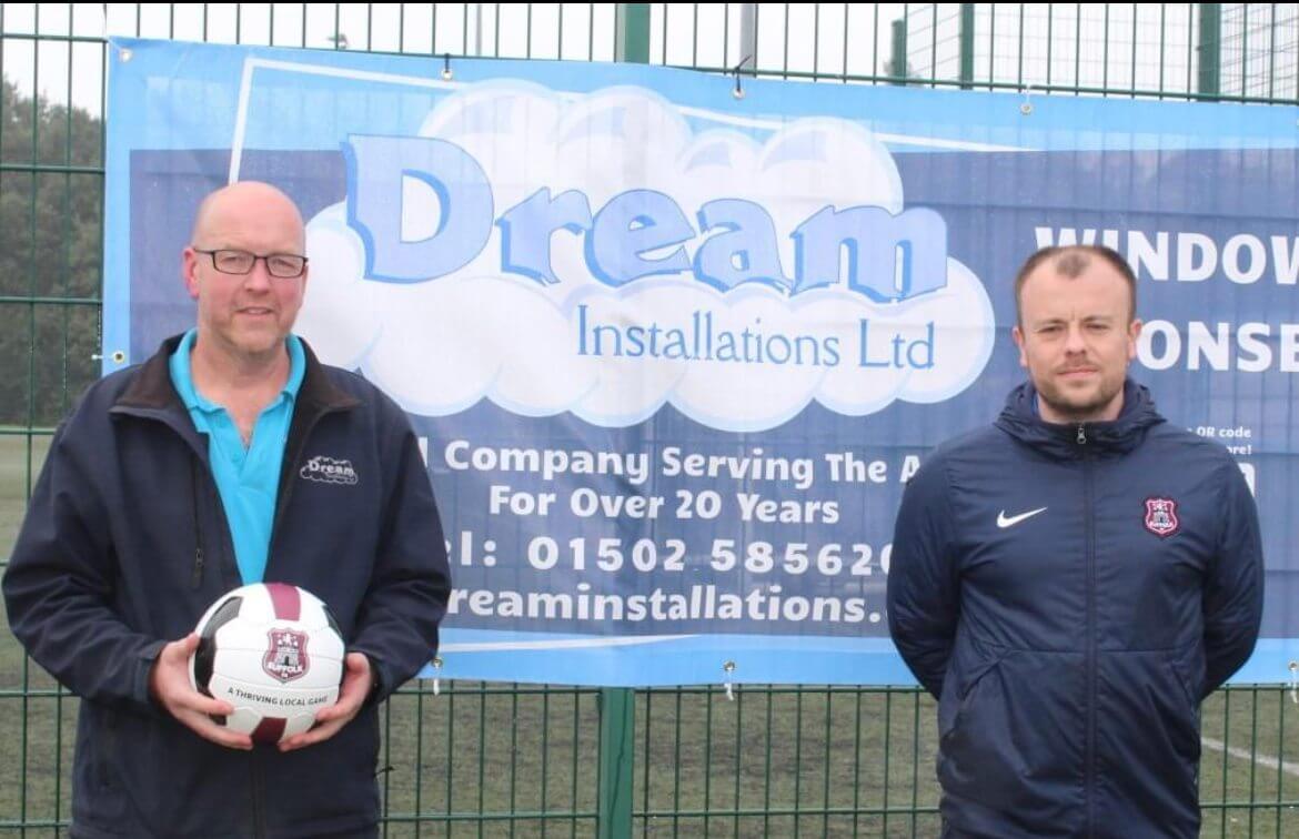 Glenn Brodie and Chris Bond standing in front of a Dream Installations sponsorship banner at Barnards Meadow Football Centre